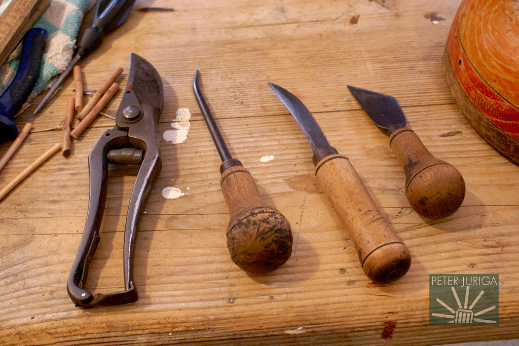 Historické náradie z počiatku 20. stor. Vľavo klasické celokovové záhradnícke nožnice, napravo od nich zahnuté šidlo, zahnutý nôž a čistič na odrezávanie koncov po dopletení. | foto: Peter Juriga